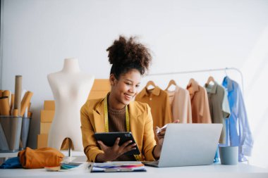 Çeşitli kadın moda tasarımcıları iş başında boyunlarında santimetre boyayla tablet ve akıllı telefon taşıyorlar.. 