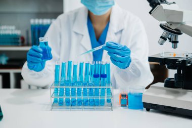 Modern tıbbi araştırma laboratuvarı. Kadın bilim adamı mikro pipetlerle çalışıyor biyokimyasal örnekleri analiz ediyor, tıp için ileri bilim kimya laboratuvarı.