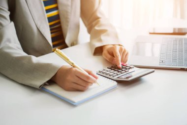 Maliyet, hesap makinesi ve tabletli dizüstü bilgisayarla ilgili finansman ile çalışan işadamı elleri, sabah saatlerinde ofiste akıllı telefon.