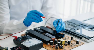 Elektronik teknisyen, elektronik mühendisliği, elektronik onarım, ölçüm ve test, onarım ve bakım kavramları. Kontrol ve yükseltme için voltaj ölçer kullanır 