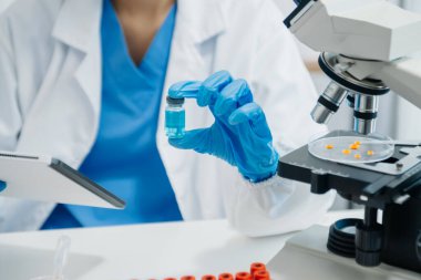 Coronavirus COVID 19 tıbbi test aşısı araştırma ve geliştirme konsepti. Laboratuar araştırmacısı Coronavirus antikorunun bilimsel örneğini analiz ediyor.