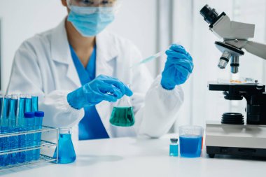 Modern tıbbi araştırma laboratuvarı. Kadın bilim adamı mikro pipetlerle çalışıyor biyokimyasal örnekleri analiz ediyor, tıp için ileri bilim kimya laboratuvarı.