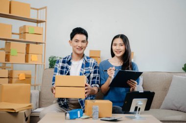 Başlangıçta küçük işletme KOBİ 'si, akıllı telefon ya da tablet kullanan girişimci sahibi erkek ve kadın ofiste online alışveriş siparişi alıp kontrol ediyorlar