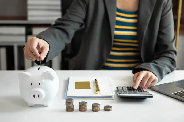 İş kadını, sanal simge diyagramı kullanarak para biriktirmek için kumbaraya para koyuyor.