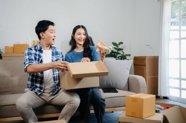 Büyük kutuları olan mutlu Asyalı genç çift yeni bir eve taşınıyor, yeni bir eve taşınıyor, yeni bir eve taşınıyor..