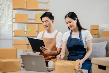 Küçük işletme girişimcisi KOBİ serbest çalışan Asyalı erkek ve kadın ofis, BOX, tablet ve laptop çevrimiçi, pazarlama, paketleme, dağıtım. 