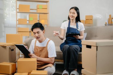 Küçük işletme girişimcisi KOBİ serbest çalışan Asyalı erkek ve kadın ofis, BOX, tablet ve laptop çevrimiçi, pazarlama, paketleme, dağıtım. 