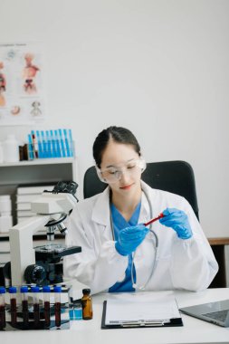 Modern tıbbi araştırma laboratuvarı. Kadın bilim adamı mikro pipetlerle çalışıyor biyokimyasal örnekleri analiz ediyor, ileri bilim kimya laboratuvarı 