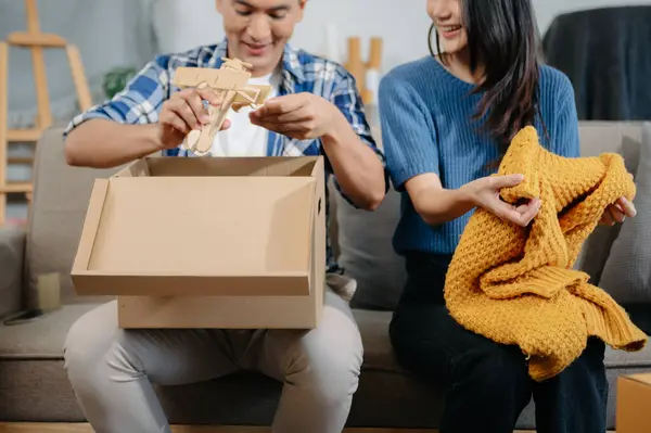 Büyük kutuları olan mutlu Asyalı genç çift yeni bir eve taşınıyor, yeni bir eve taşınıyor, yeni bir eve taşınıyor..