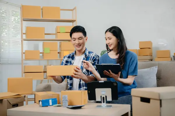 Başlangıçta küçük işletme KOBİ 'si, akıllı telefon ya da tablet kullanan girişimci sahibi erkek ve kadın ofiste online alışveriş siparişi alıp kontrol ediyorlar