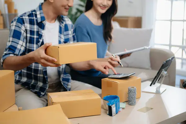 Küçük işletme girişimcisi KOBİ serbest çalışan Asyalı erkek ve kadın ofis, BOX, tablet ve laptop çevrimiçi, pazarlama, paketleme, dağıtım. 