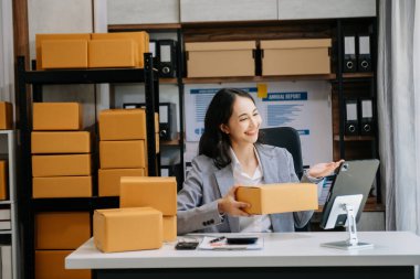 İş yerinde bir kutuyla çalışan Asyalı kadın KOBİ. Küçük işletme sahibi, küçük işletme girişimcisi KOBİ ve dağıtım konsepti kurun. 