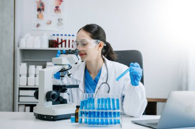 Modern tıbbi araştırma laboratuvarı. Kadın bilim adamı mikro pipetlerle çalışıyor biyokimyasal örnekleri analiz ediyor, ileri bilim kimya laboratuvarı 