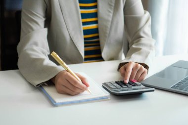 Maliyet, hesap makinesi ve tabletli dizüstü bilgisayarla ilgili finansman ile çalışan işadamı elleri, sabah saatlerinde ofiste akıllı telefon.