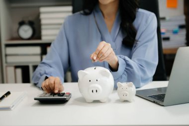 İş kadını kumbaraya para yatırıyor ve para biriktirmek için para biriktiriyor.