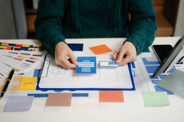 UI müteahhitlerinin projelerini dizüstü bilgisayar, akıllı telefon ve dijital tablet ile beyin fırtınası yaparken görüntülerini kapatın. Yaratıcı dijital geliştirme ajansı