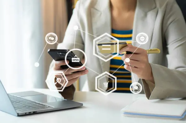 Mobil ödemeler için akıllı telefon kullanan bir kadın çevrimiçi alışveriş, Omni kanalı, masada oturan, sanal simge grafik arayüzü ekranı