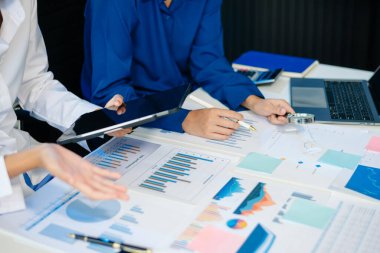 Ofis masasında akıllı telefon ve hesap makinesi olan iş belgeleri dijital tablet ve sosyal ağ diyagramı olan grafik işleri ve ofiste çalışan iki iş arkadaşı