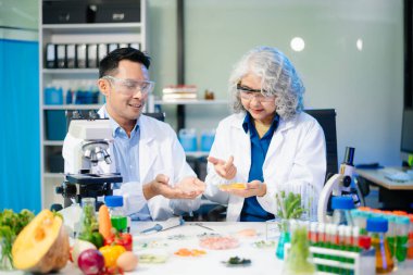 Team of scientists examining food samples in a lab with microscopes. Perfect for themes of food science, biotechnology, and nutrition research teamwork