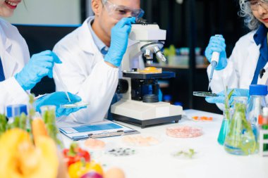 Team of scientists examining food samples in a lab with microscopes. Perfect for themes of food science, biotechnology, and nutrition research teamwork