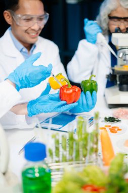 Team of scientists examining food samples in a lab with microscopes. Perfect for themes of food science, biotechnology, and nutrition research teamwork