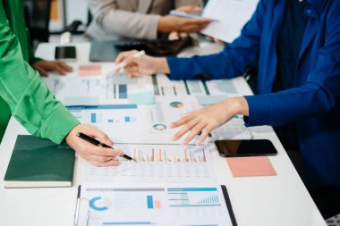 İş adamları ofiste toplanıp laptoplar, tablet planlama ve iş arkadaşları için beyin fırtınası stratejileri hakkında notlar yazıyorlar.