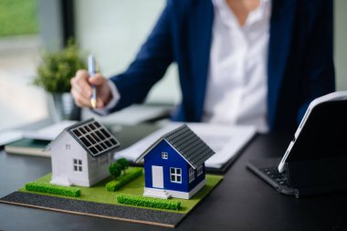 Emlak sektörünü dengelemek için emlakçı ev tasarımını ve satın alma anlaşmasını görmek için ev tarzını açıklıyor. Ofiste model ev ve komdo.