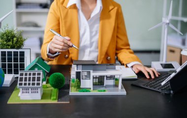 Emlak sektörünü dengelemek için emlakçı ev tasarımını ve satın alma anlaşmasını görmek için ev tarzını açıklıyor. Ofiste model ev ve komdo.