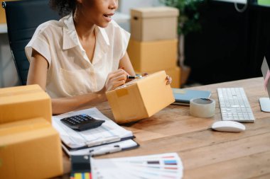 Woman Entrepreneur: SME Business mastering e-commerce with tablet, laptop, packaging, with Online Marketing, Packaging, and delivery