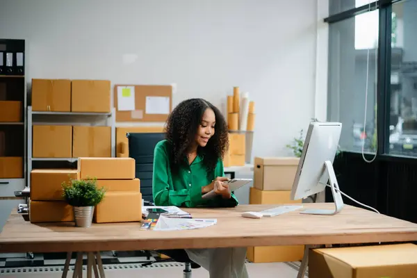 Küçük işletme girişimcisi KOBİ 'de çalışan serbest çalışan kadın ofis, BOX, tablet ve laptop çevrimiçi, pazarlama, paketleme, dağıtım, e-ticaret konsepti