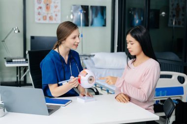  Doctor discussing treatment with Female patient talks to discuss results or symptoms and sitting on examination desk in clinic or hospital