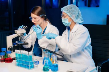 Modern Medical Research Laboratory Portrait of Two Scientists Working, Using Digital Tablet, Analyzing Samples, Talking. for Medicine, Biotechnology