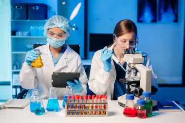 Modern Medical Research Laboratory Portrait of Two Scientists Working, Using Digital Tablet, Analyzing Samples, Talking. for Medicine, Biotechnology