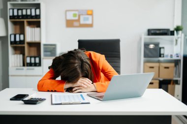 business woman is stressed, bored, and overthinking from working on a tablet at the office.