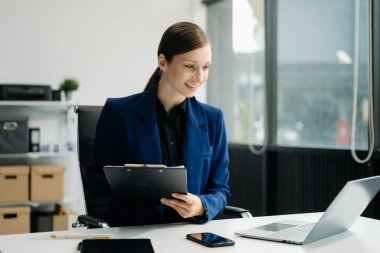 Young attractive female office worker business suits smiling at office