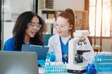 Scientist two woman with tablet and laptop, laboratory and ecofriendly science. Agriculture, research and scientists with online reading, test samples for global warming, analytics 
