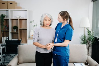 Doctors explain the use of medication to patients. Medical doctor holing senior patient's hands and comforting her on sofa at home