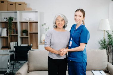 Doctors explain the use of medication to patients. Medical doctor holing senior patient's hands and comforting her on sofa at home
