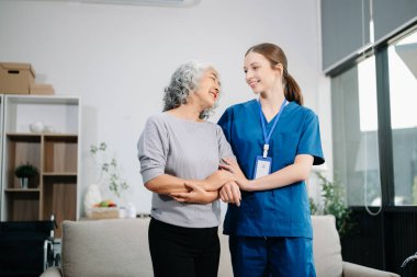 Doctors explain the use of medication to patients. Medical doctor holing senior patient's hands and comforting her on sofa at home