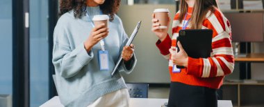 Female discussing new project with male colleague. Young woman talking with youg business in office