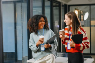Female discussing new project with male colleague. Young woman talking with youg business in office