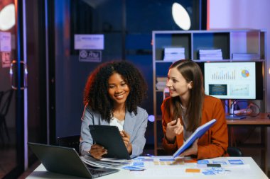 Ofiste yeni bir proje üzerinde çalışırken mutlu iş adamları. Ofiste bir dizüstü bilgisayar ve tablet kullanan iki işadamı.