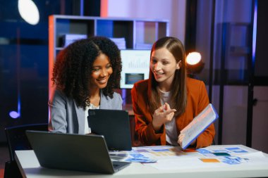 Ofiste yeni bir proje üzerinde çalışırken mutlu iş adamları. Ofiste bir dizüstü bilgisayar ve tablet kullanan iki işadamı.