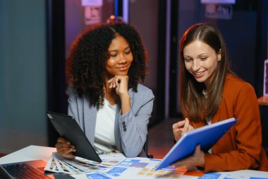 Ofiste yeni bir proje üzerinde çalışırken mutlu iş adamları. Ofiste bir dizüstü bilgisayar ve tablet kullanan iki işadamı.