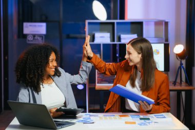 Ofiste yeni bir proje üzerinde çalışırken mutlu iş adamları. Ofiste bir dizüstü bilgisayar ve tablet kullanan iki işadamı.