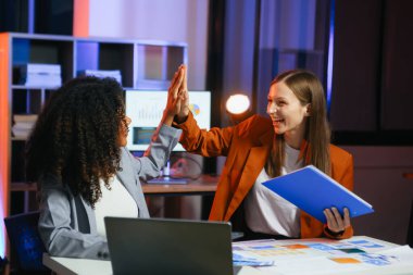 Ofiste yeni bir proje üzerinde çalışırken mutlu iş adamları. Ofiste bir dizüstü bilgisayar ve tablet kullanan iki işadamı.