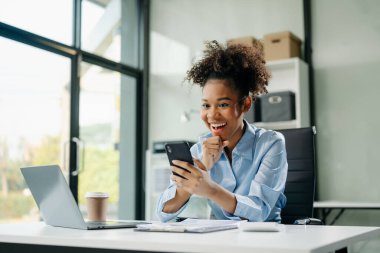 Young business woman are delighted and happy with the work they do on their tablet, laptop and taking notes at the office.