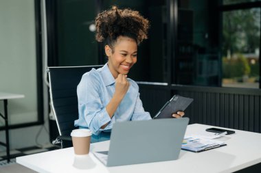 Young business woman are delighted and happy with the work they do on their tablet, laptop and taking notes at the office.