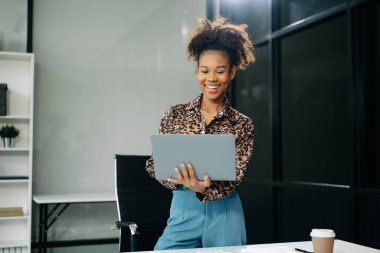 Çalışan not defteri, tablet ve dizüstü bilgisayarla çalışan genç iş kadını akıllı telefon, tablet ve dizüstü bilgisayarla konuşuyor. Video arama vergisi, rapor, muhasebe