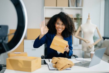 Beautiful lady blogger showing clothes in front of the camera to recording vlog video live 